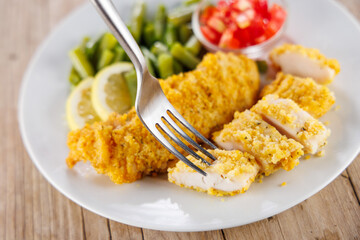 fried breaded chicken fillet with bean and tomatoes