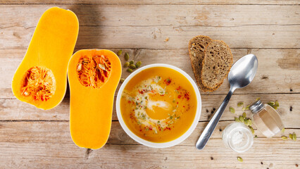 pumpkin soup and bread on wooden background