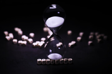 Sand running through the bulbs of an hourglass measuring the passing time in a countdown to a...