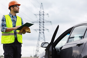 A man in a helmet and uniform, an electrician in the field. Professional electrician engineer...