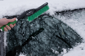 Cleaning Car Windshield from Snow with Brush