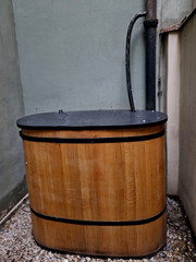 use of rain roof at new school building. overflow from roof flows down pipe into barrel with hose...