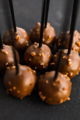 Round chocolate candies on a black background. Group of chocolate candies. Concept of chocolate products