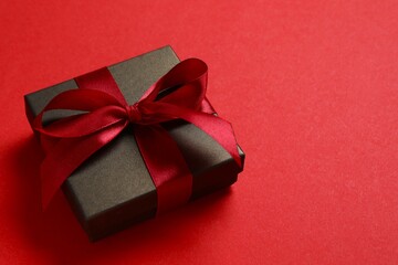 Beautiful gift box tied with bow on color background 