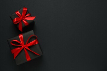 Beautiful gift boxes tied with bows on black background 