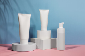 White cream tube on podium mockup on a blue background. The concept of cosmetology, body and face care