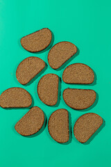 Pattern of dark rye bread slices on teal