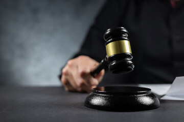 judge's gavel in hand judges is placed on a table in the legal counsel's office