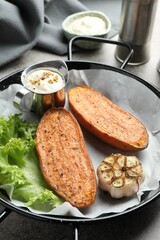 Tasty cooked sweet potato in baking dish served on grey textured table