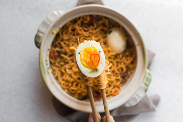 Overhead view of soft boiled eggs, top view of soft boiled egg yolk on a chopstick