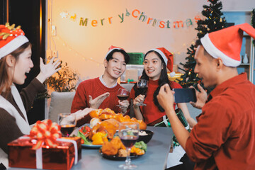 Group of young Asian man and women as friends having fun at a New Year's celebration, holding gift...