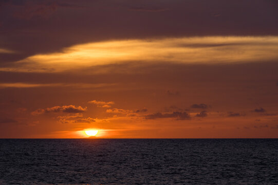 Tranquil ocean sunset with vibrant sky and gentle waves