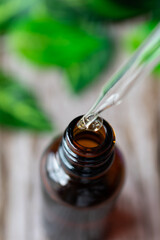 A close up, top-view of a dropper taking some essential oil from an amber vial.