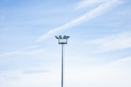 Tall stadium floodlight under a clear blue sky