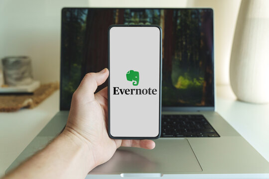  Evernote application logo on smartphone screen in front of laptop