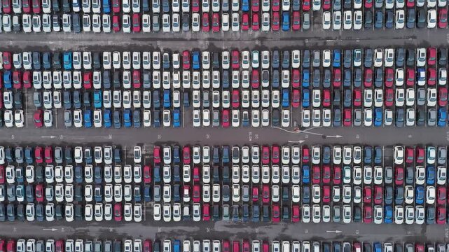 Abstract aerial composition featuring systematic arrangement of vehicles creating visual data patterns, emphasizing geometric organization and scale of automotive logistics