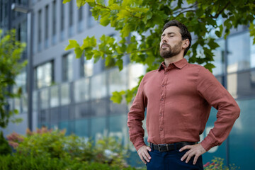 Mature businessman standing confidently in city environment, eyes closed, embracing tranquility and...