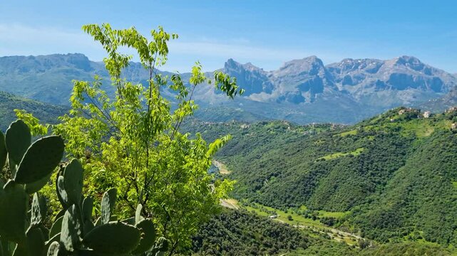 Breathtaking view over mountains, green hills and valleys and small hilltop settlement in the Kabylie region of North Algeria on a sunny and pleasant day