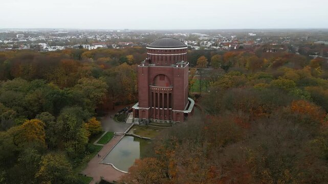 a big tower standing in the middle of a green park surrounded by trees, Hamburg, germany, europe, drone