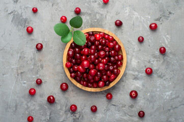 Cranberries in a wooden bowl on a dark background. Horizontal, top view, free space. Vitamins, benefits.