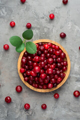 Cranberries in a wooden bowl on a dark background.  top view, free space. Vitamins, benefits.