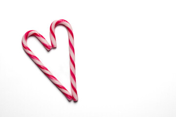 Heart shape created by candy canes on a white background perfect for holiday celebrations