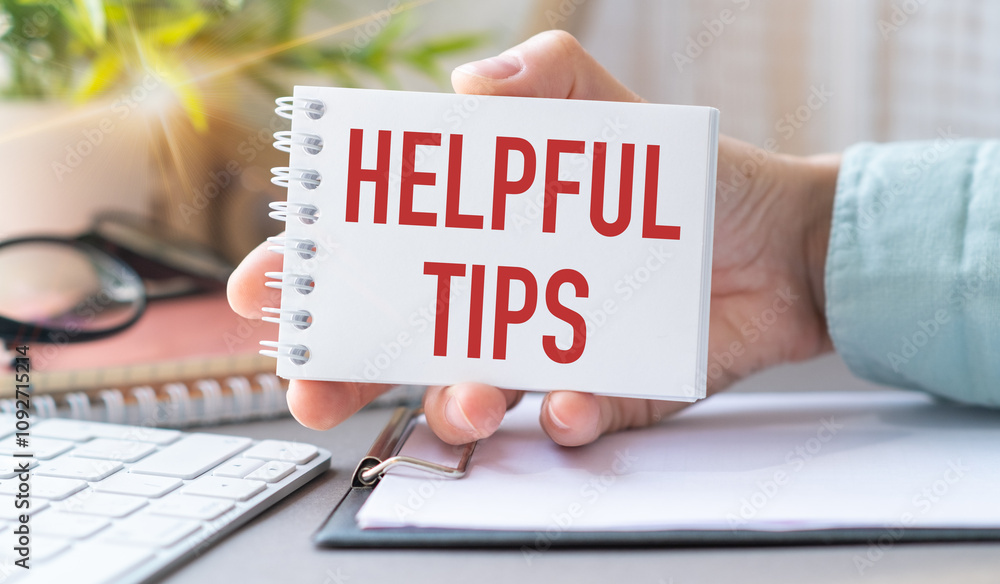 Poster helpful tips text on an open notebook in hand, calculator, business concept
