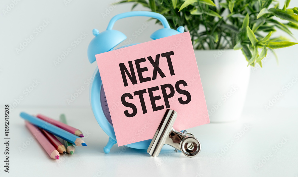 Poster next steps text on clock. text on office paper notepad