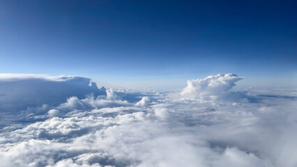 Clouds in the blue sky, view from the window of an aircraft