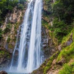 Obraz premium Rainbow Waterfall: A long shot of a waterfall flowing with rainbow colors, viewed from below.