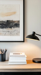 Stylish home office desk features an abstract painting, pencils, books, and a desk lamp illuminating the workspace at midday