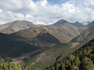 View of landcape with mountains and hills. Beautiful clouds above mountains. Vivid natural scenery...