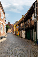 a beautiful city scape view through the small streets in the town Ribe in Denmark. With small and historic half-timbered houses in tiny alleys.