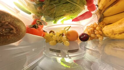 A 360-degree view inside a refrigerator showcases vibrant fruits, vegetables, and eggs in an organized and bright setting, creating a seamless loop of rotating motion.