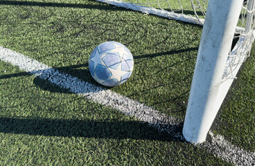  soccer ball flies into the gate on a green background. Close up.