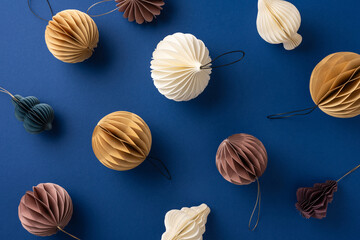 A collection of sophisticated paper ornaments arranged on a dark blue surface. This image conveys a festive and artistic vibe, perfect for holiday decoration inspiration