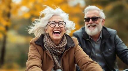 Fototapeta premium Joyful older couple biking in autumn park, vibrant retirement lifestyle imagery