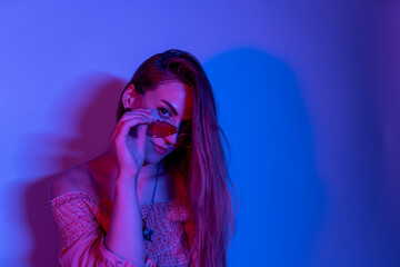 Portrait of young woman in neon light studio