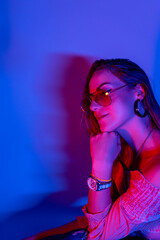 Portrait of young woman in neon light studio