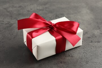 Gift box with bow on grey table