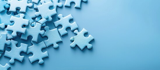 A pile of blue puzzle pieces on a light blue background.