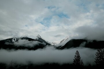 Misty mountain landscape with snow-capped peaks.