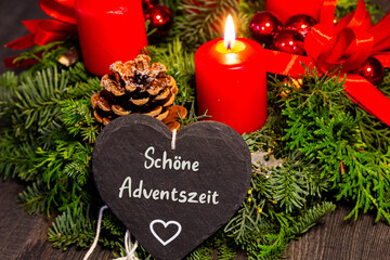 Adventsgrüße: Herz mit der Aufschrift SCHÖNE ADVENTSZEIT vor einem Adventskranz