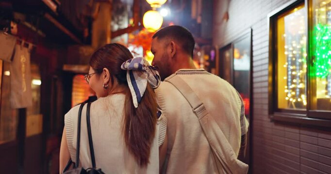 Back, tourist and couple in night, city and bonding on vacation, talking and romance for valentines day. Travel, exploring and anniversary for people on holiday, tourism and love for market in Japan