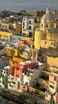Marvelous sunset view of Island of Procida. Naples, Italy. Colourful italian houses in Corriccella village in Procida island. Panning vertical shot