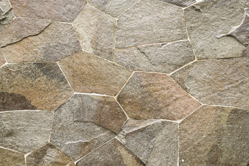 A close up view of a stone background, showcasing its rough and textured surface. The natural colors and patterns of the stone create a rugged and earthy aesthetic