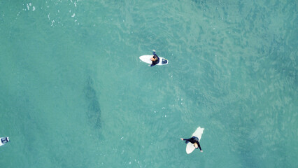 Fototapeta premium Surfers on their boards are waiting for their next wave