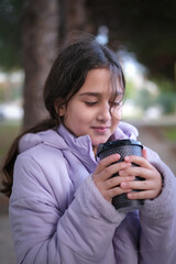 Beautiful girl drinking hot chocolate in a cold winter day.
