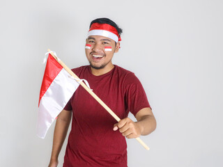 Excited young Asian men celebrate Indonesian independence day on 17 August by holding the...
