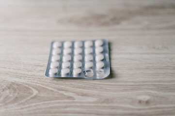 A box of pills is on a wooden table